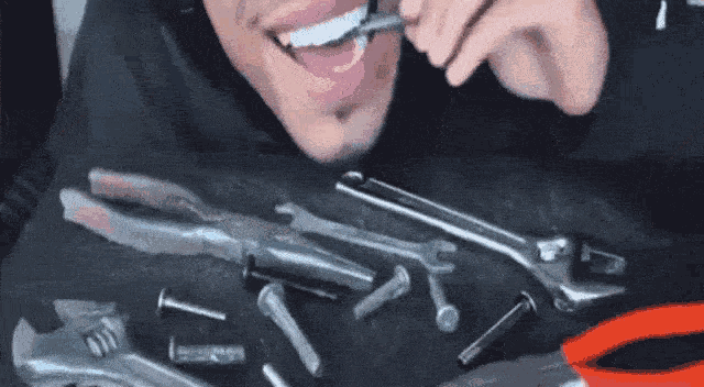 guy eating metal tools and bolts and such