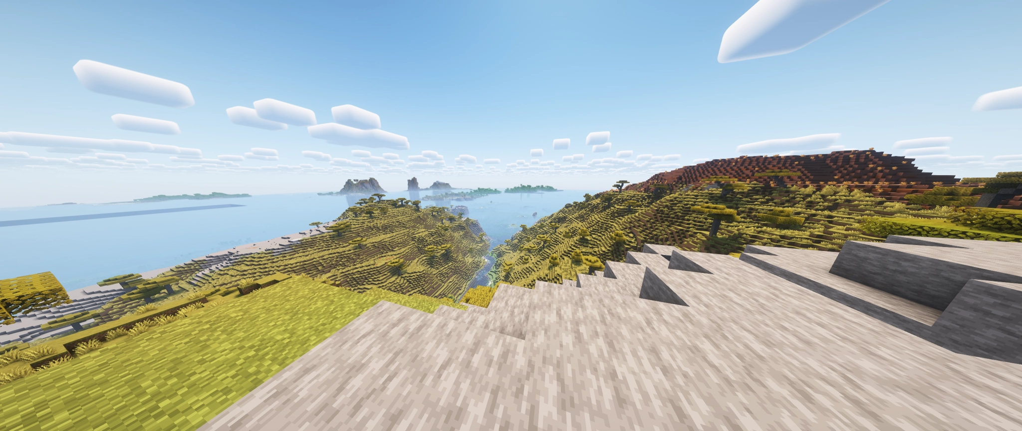 view on top of a mountain on the island showing how far up and down the entire island goes and a few others off in the distance