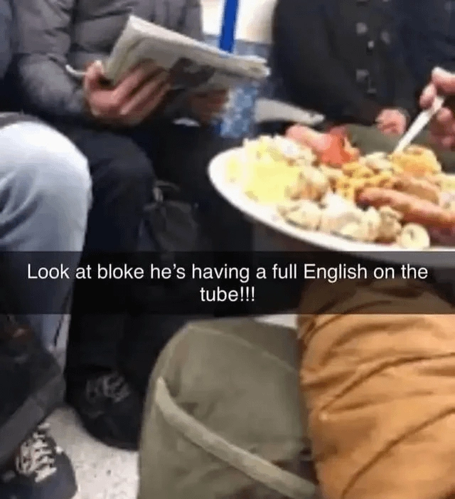 a guy eating a full english breakfast on the tube with a snapchat caption that says "Look at bloke he's having a full English on the tube!!!"