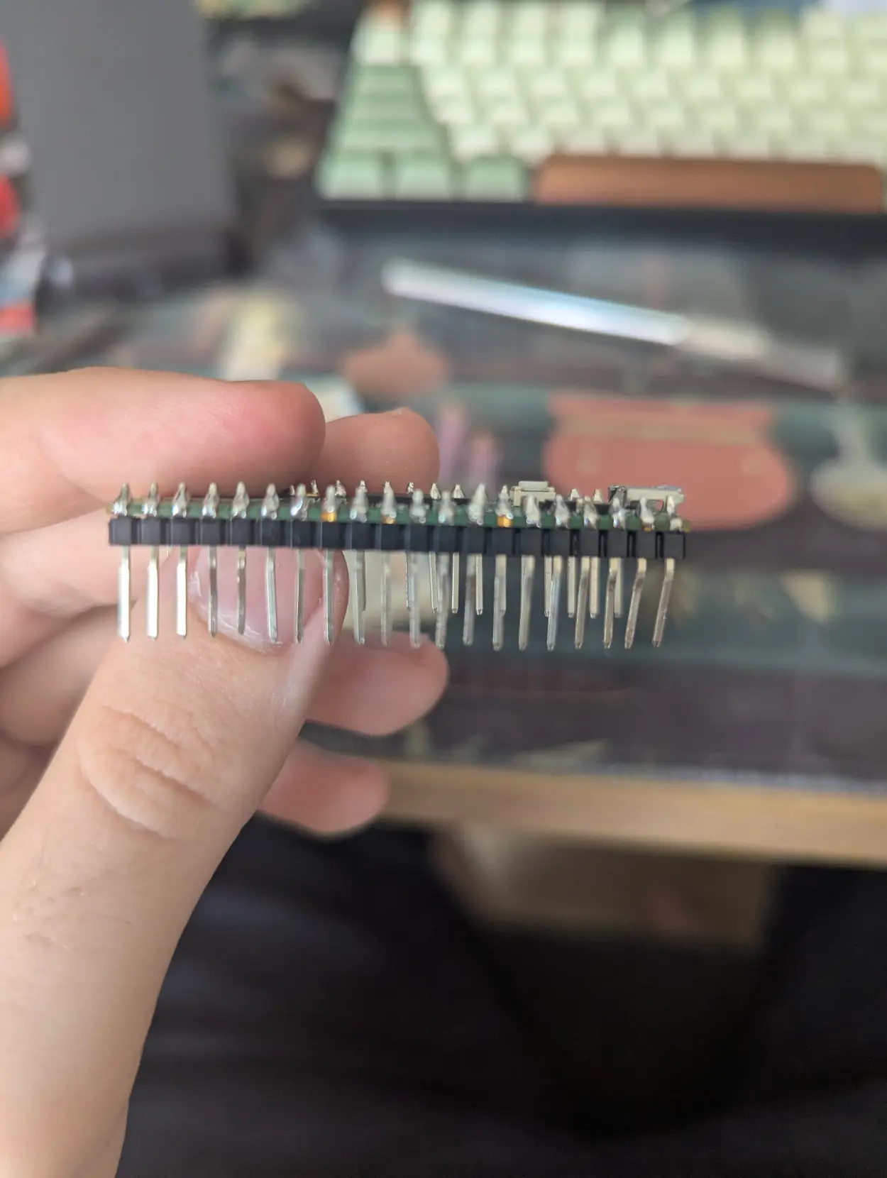 raspberry pi zero with pins soldered to it and the pins that plug into the breadboard are wonky as hell