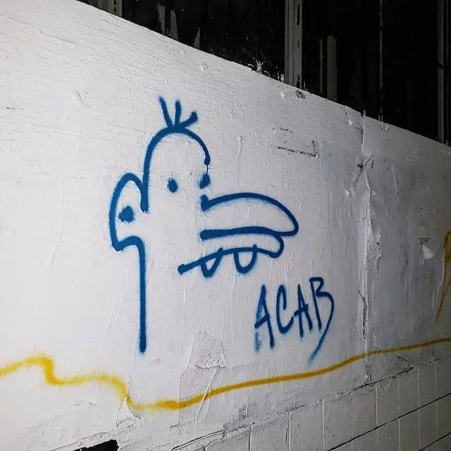 manny's face spray painted on a wall with ACAB