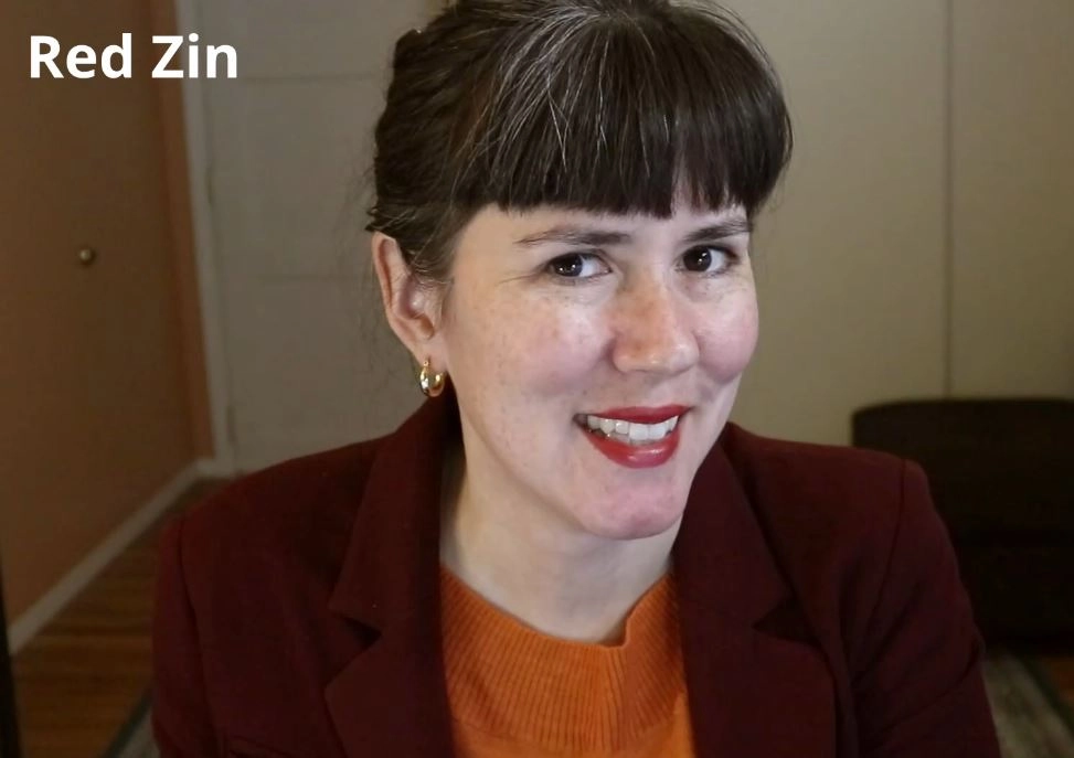 a woman wearing a red coat and orange jumper smiling with lipstick and the text "Red Zin" in the top left